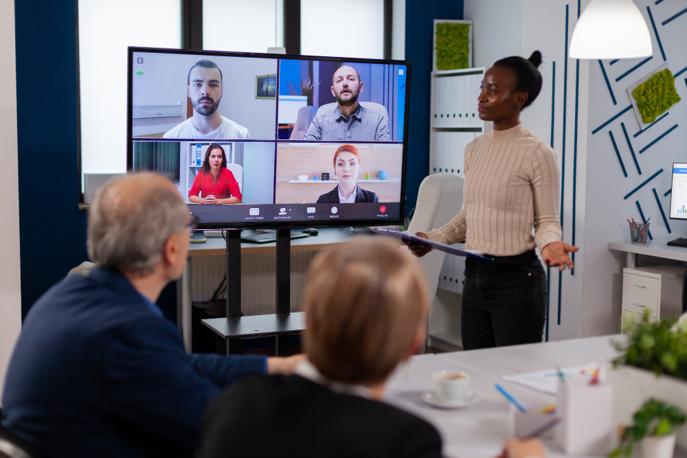 black manager woman talking with remotely colleagues video call tv screen presenting new business partners