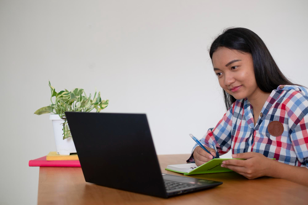 happy young girl studying with laptop home